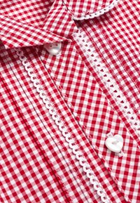 Roter und weißer Gingham-gewebter Stoff mit einem Kentkragen. Verziert mit weißer Spitzenborte und Herzformknöpfen.