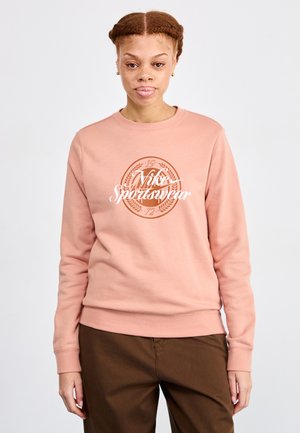 Lichtroze sweatshirt met een wit "Nike Sportswear" logo en een cirkelontwerp. De stof lijkt zacht met ribgebreide manchetten en zoom.
