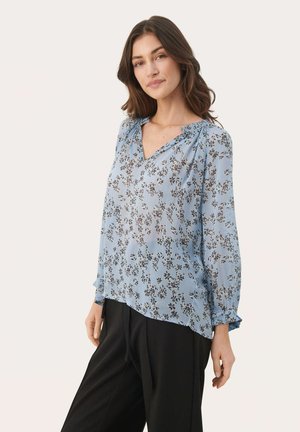 Hellbluse aus durchsichtigem Stoff mit schwarzem Blumenmuster, V-Ausschnitt, Faltendetails und langen Ärmeln mit gerafften Bündchen.