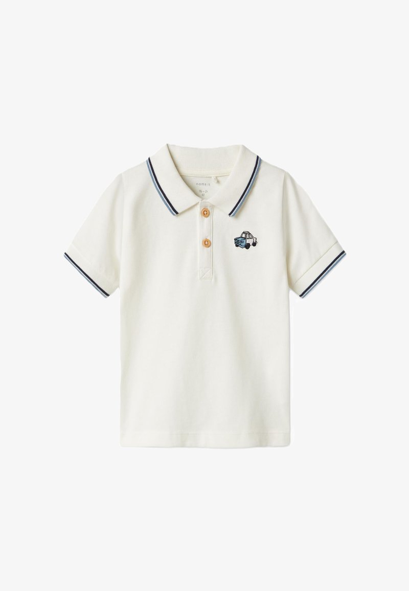 Polo en coton écru avec un col à rayures bleues, comportant trois boutons marron et un motif de voiture brodé sur la poitrine gauche.