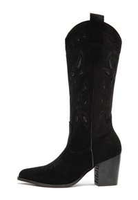 Botte de cowboy en suède noire avec un bout pointu, des coutures décoratives et des motifs floraux découpés. Dotée d'un talon épais et d'une languette de tirage.