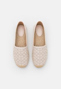 Espadrillas beige con un motivo perforato, suole in juta e accenti cuciti. Finitura liscia e design con punta arrotondata per un look casual.