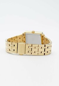 Orologio da polso in metallo dorato con quadrante quadrato, design a bracciale collegato e chiusura a fibbia. Presenta un quadrante argentato minimalista.