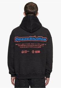 Svart hettegenser med fet rød og blå tekst på baksiden, inkludert "DpszeStudios" og motiverende setninger, med ribbede mansjetter.