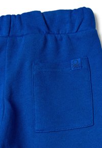Niebieskie bawełniane spodnie dresowe z elastycznym pasem, gładką fakturą i kwadratową kieszenią na tył z dopasowanym logo.