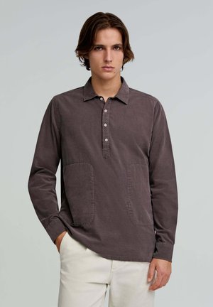 Long-sleeve shirt in dark gray fabric, featuring a buttoned placket, two front pockets, and a relaxed fit. Smooth texture with a collar.
