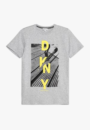 Graues T-Shirt mit kurzen Ärmeln mit schwarz-weißem Grafikdesign von Holzplanken und Schatten, darüber große gelbe Buchstaben D, K, N, Y.