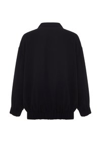 Sweat-shirt noir surdimensionné avec un col montant, des poignets et un ourlet élastiqués, fabriqué à partir d'un tissu doux, présentant une texture lisse et un design simple.