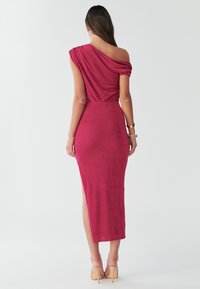 One-shoulder, form-fitting, burgundy dress made of smooth fabric. Features a side slit and gathered design at the shoulder. Clear smooth texture.