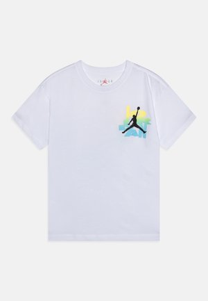 T-shirt blanc à manches courtes avec texte coloré "JORDAN" et logo de basketball Jumpman noir sur la partie gauche de la poitrine.