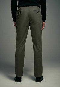 Pantalons pour hommes en vert olive avec une texture lisse, une coupe droite, des poches arrière avec boutons et un ourlet soigné.