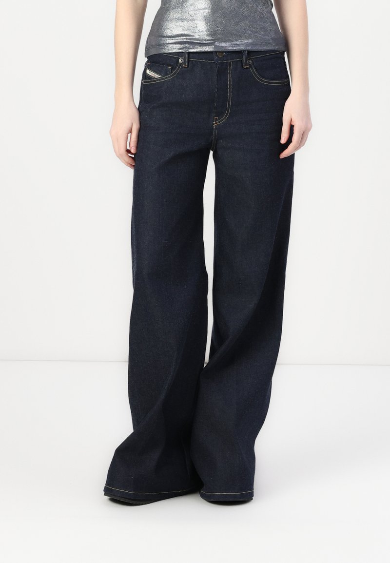 Dunkelblaue breite Jeans mit hoher Taille, die klassische Taschen und gelbe Nähte aufweist. Aus Denim gefertigt, bietet sie eine strukturierte Passform.