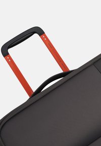 Valigia nera con superficie testurizzata, dotata di un manico estraibile arancione e una presa nera. Il design è elegante e moderno.