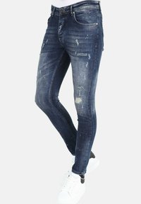 Skinny denim jeans in donkerblauw met verwerkte details, verfspatten en vervaging. Voorzien van een klassiek vijf-pocket ontwerp en knoopsluiting.