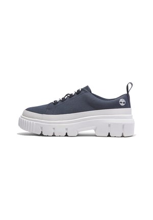 Sneaker basse blu navy con suola bianca spessa e robusta, chiusura con lacci, linguetta sul tallone e piccolo logo ad albero vicino al tallone.