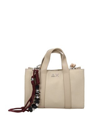 Borsa beige con due manici corti, decorata con un cordoncino bordeaux e perline nere e argento appese da un lato.