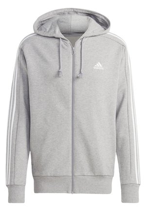 Felpa grigia con chiusura a zip realizzata in tessuto morbido, dotata di cappuccio, tasche frontali e dettagli a tre strisce bianche lungo le maniche. Logo Adidas sul petto.
