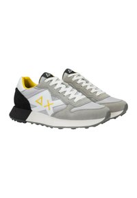 Zapatillas grises y blancas con acentos amarillos, hechas de ante y malla. Presentan un talón negro y cordones blancos, con una suela de goma texturizada.