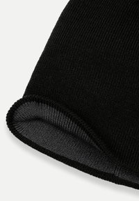 Černá pletená čepice s ohrnutým okrajem, která má měkkou texturu a kontrastní šedé podšívání uvnitř. Jednoduchý, elegantní design.