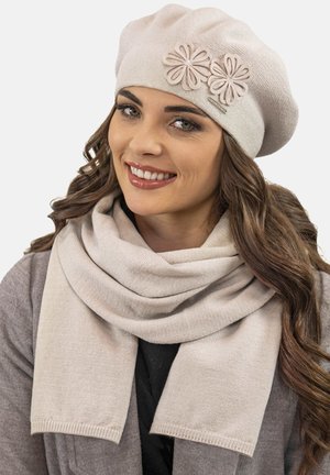 Béret en laine beige clair avec des fleurs en feutre décoratives et un accent argenté ; accompagné d'une écharpe douce assortie dans une teinte similaire.