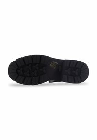 Semelle noire de chaussure avec des rainures profondes et des grips en forme de triangle, accompagnée d'un logo rectangulaire près du centre.