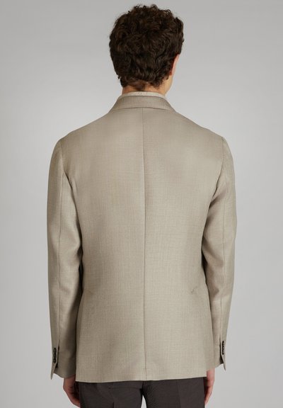 Beżowa marynarka w jodełkę o eleganckim, wyrafinowanym kroju. Posiada wykładany kołnierz i mankiety na guziki. Prosty tył z delikatną fakturą.