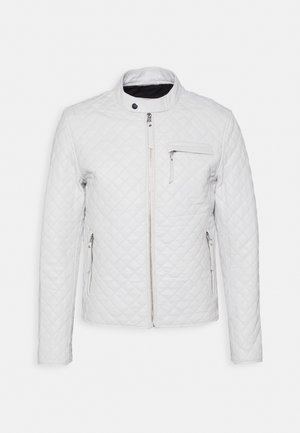 Veste matelassée blanche avec zip avant, col montant avec bouton-pression et trois poches zippées sur la poitrine et les côtés.