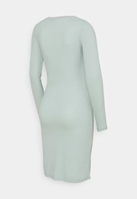 Långärmad, ribbad klänning i mintgrön, med rund halsringning och figurnära passform, i en slät, texturerad tyg.