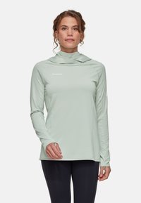 Ljusgrön långärmad topp med cowl-halsringning, tillverkad av ett glatt, stretchigt material; har logga på bröstet och tumhål i ärmarna.