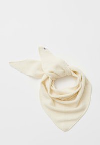 Sjaal in roomkleur, gemaakt van zacht materiaal, met een driehoekige vorm en puntige uiteinden, voorzien van een klein label in één van de hoeken.