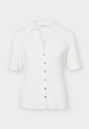 Bílá krátká košile s límečkem, se zapínáním na šest kovových knoflíků vpředu a s přiléhavým střihem, na jednobarevném pozadí.