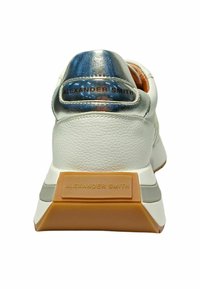 Sneaker bianco con tomaia in pelle testurizzata, dettagli metallici blu e argento sul tallone, e suola in gomma spessa con marchio.