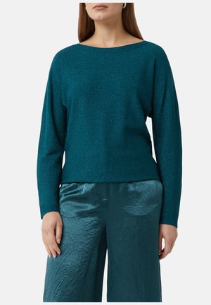 Pull turquoise à manches longues avec un col large, fabriqué en tissu pailleté. Assorti avec un pantalon large plissé de la même couleur.