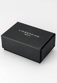 Boîte rectangulaire noire texturée avec "Liebeskind Berlin" imprimé en blanc, présentant une finition lisse et des bords nets.