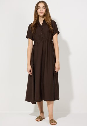 Braunes, kurzärmliges Midi-Kleid mit Kragen und Knopfleiste. Der elastische Bund sorgt für eine fließende Silhouette. Kombiniert mit goldakzentuierten Sandalen.