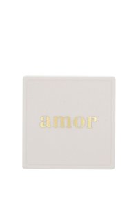 Fyrkantig keramikskål i mjukt beige med en glänsande yta, med ordet "amor" i guldfoliering centrerat på ytan.