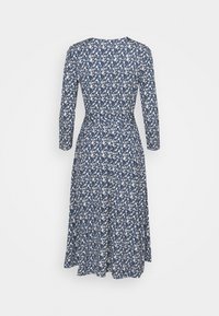 Robe bleue à manches longues avec motif floral blanc, taille cintrée et jupe évasée, vue de dos sur fond uni.