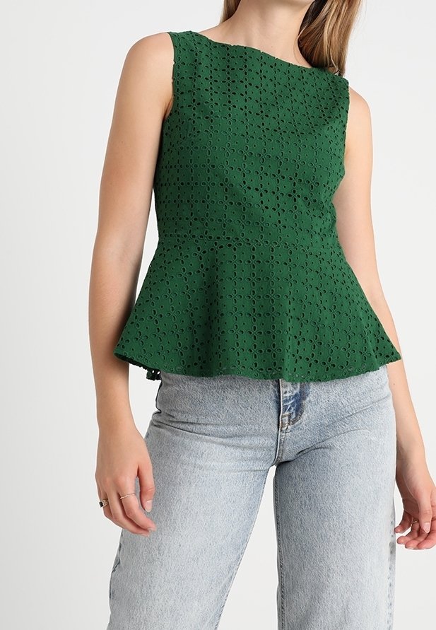 Top peplum verde hecho de un tejido texturizado con un patrón de agujeros cortados. Diseño sin mangas con un cuerpo ajustado y un dobladillo acampanado.