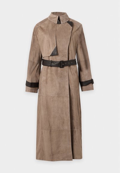 Long trench en daim beige avec ceinture en cuir noir, détail col en cuir noir et bracelets en cuir noir aux manches.