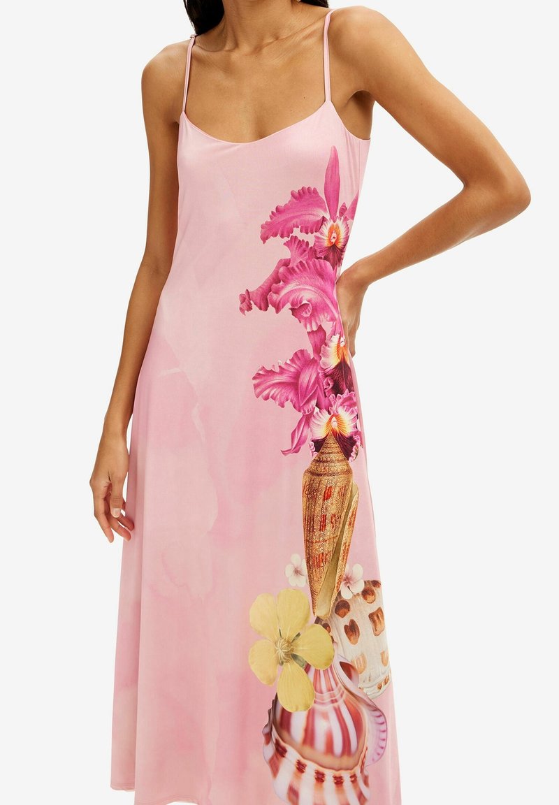 Vestido slip con estampado floral en suave tela rosa, que presenta orquídeas vibrantes y jarrones decorativos con acentos amarillos y patrones. Tirantes ajustables.