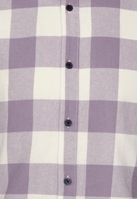 Lila-weiße karierte Hemd mit Knopfdesign, schwarzen Knöpfen und strukturiertem Stoff.