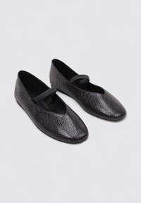 Bailarinas de imitación de piel de serpiente negra con puntera redonda y una correa delgada sobre el empeine. Textura suave y diseño minimalista.