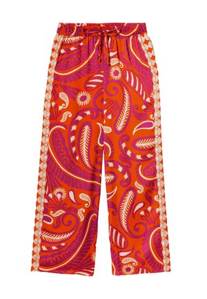 Pantalon large rouge avec un motif paisley et floral vibrant en rose et blanc. Présente une taille élastique et un cordon de serrage.