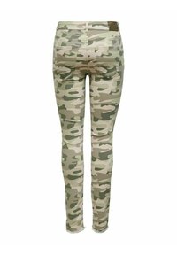 Jeans skinny de camuflaje en tonos de verde y beige, con un dobladillo deshilachado y dos bolsillos traseros. Fabricados con un material de mezclilla elástico.