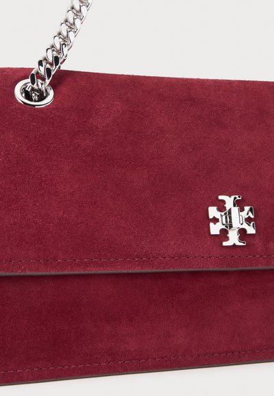 Τσάντα χειρός από βαθύ κόκκινο σουέτ με ασημένιο λουράκι αλυσίδας και μικρό ασημένιο λογότυπο στην μπροστινή πτυχή.