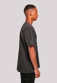 Black cotton t-shirt with short sleeves, featuring a colorful graphic on the front. Relaxed fit with a round neckline and a straight hem.