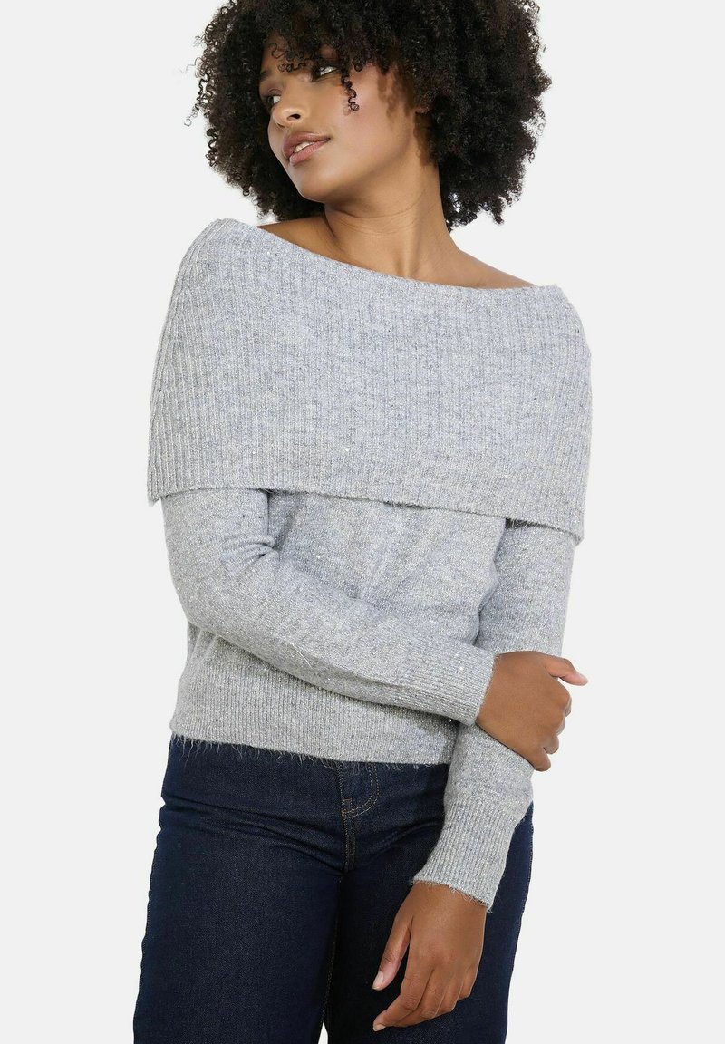 Gray off-the-shoulder sweater with a ribbed texture, long sleeves, and a soft fabric. Worn with dark denim jeans.