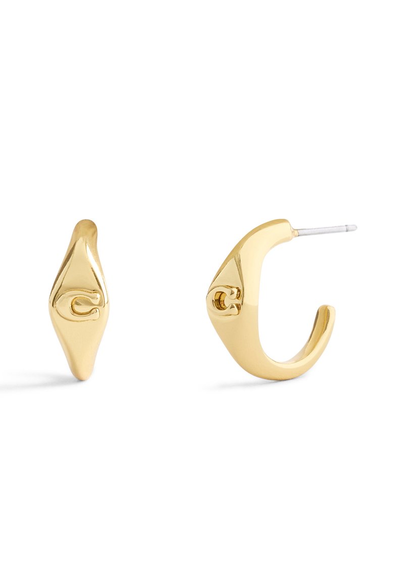 Orecchini a cerchio in oro con una texture liscia e lucida, caratterizzati da un design curvato unico e un piccolo dettaglio con logo su un orecchino.