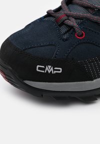 Scarpe da trekking in suede e rete blu scuro con suola in gomma nera, dettagli grigi e lacci decorati. Logo CMP visibile sul lato.