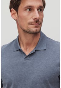 Tummansininen polo-paita, jossa on kauluksellinen kaula-aukko, hienosti teksturoitu kangas, sisältäen kaksinappisen joustavan kauluksen ja lyhyet hihat.